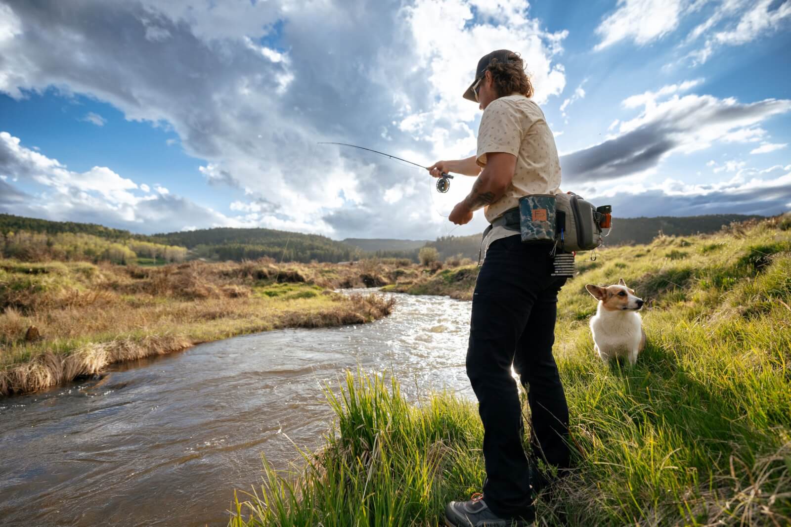 An angler fishing in a scenic Wyoming stream, surrounded by open landscapes, making it one of the best places to go fishing near the Bighorn Mountains.