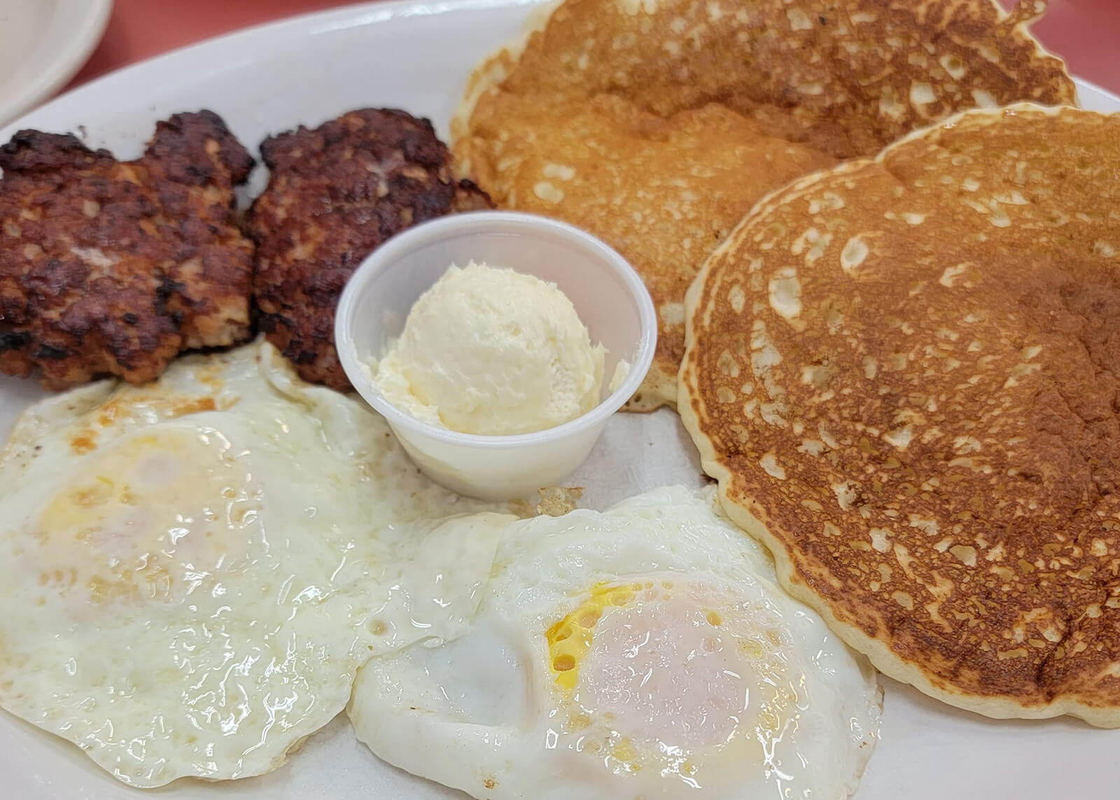 Close up of eggs, pancakes and sausage on a plate at Main Street Diner