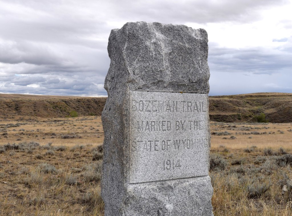 The stone marker for the Bozeman Trail with Bozeman Trail Marked by the State of Wyoming 1914 chiseled in the grey stone.