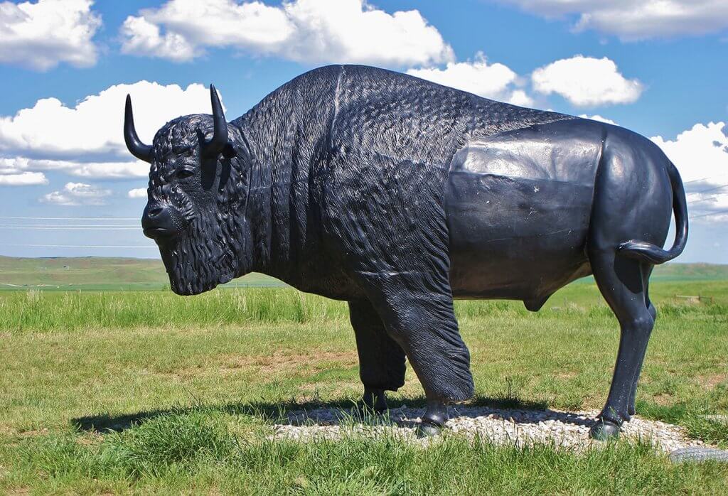 A large black bison statue at Mountain Plains Heritage Park, an interesting outdoor spot for family-friendly exploration near Buffalo, WY.