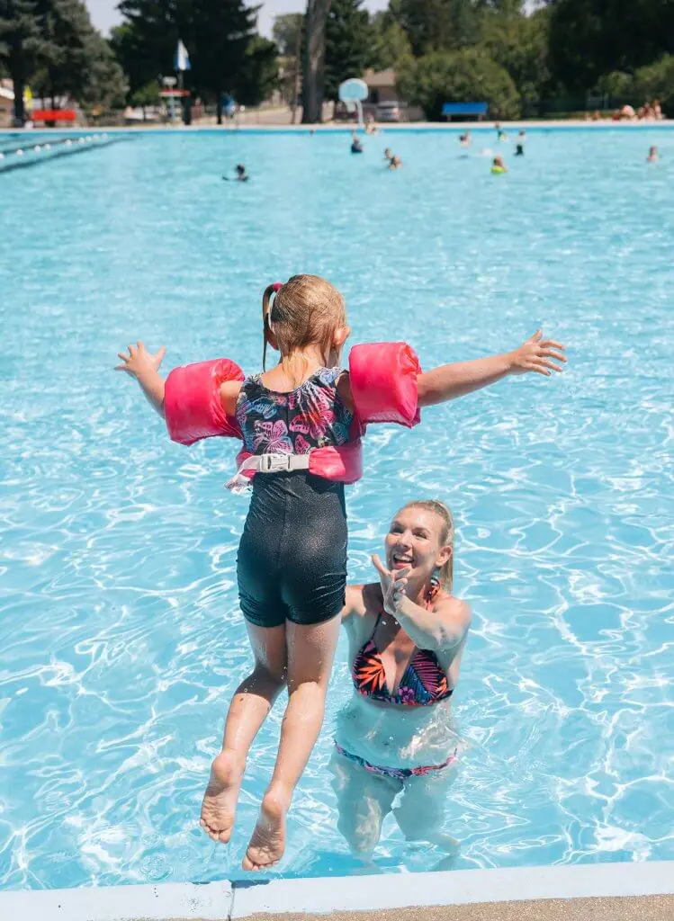 A mother catching her daughter jumping into the Municipal Pool, a fun thing to do with kids in Buffalo, WY.