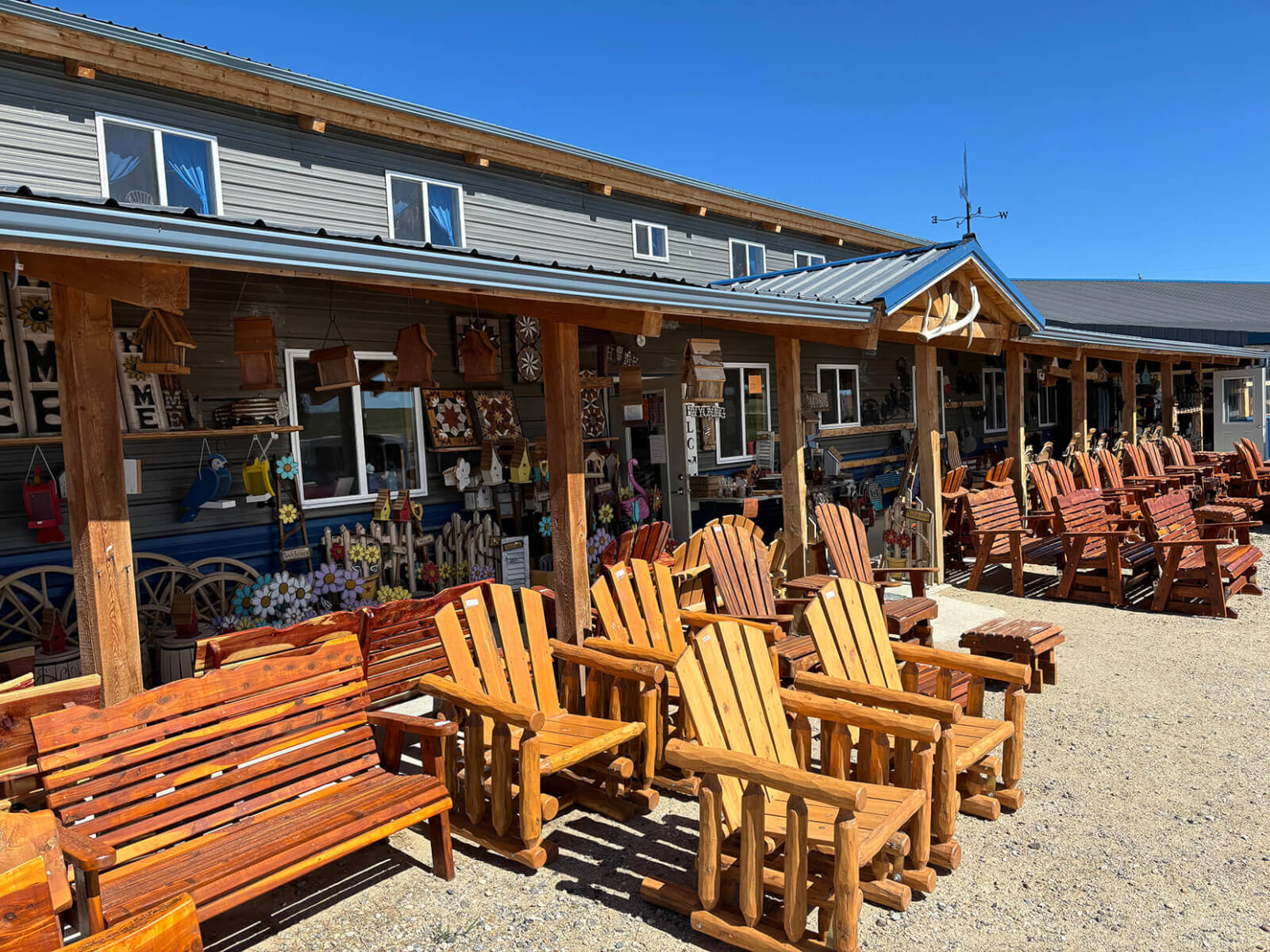 Wooden outdoor furniture displayed outside Yoder's Country Store, a charming spot for family shopping in Buffalo, WY.