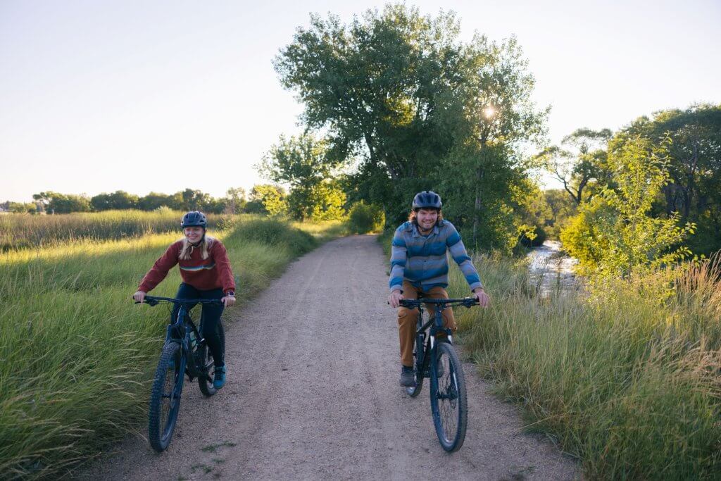 Explore top things to do in Buffalo, Wyoming. Couple biking along the Clear Creek Trail System,  enjoying the scenic route.