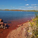 An image of Lake DeSmet with its red stone shore.