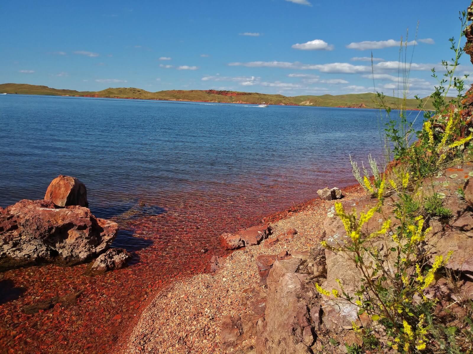 An image of Lake DeSmet with its red stone shore.