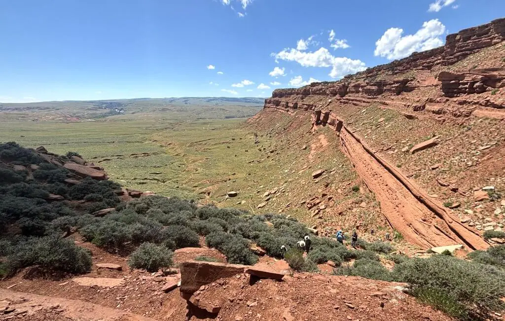 Hikers on the rugged Hole in the Wall Foot Trail, a historic red rock canyon path in Buffalo, Wyoming, known as one of the top places to hike in Buffalo.