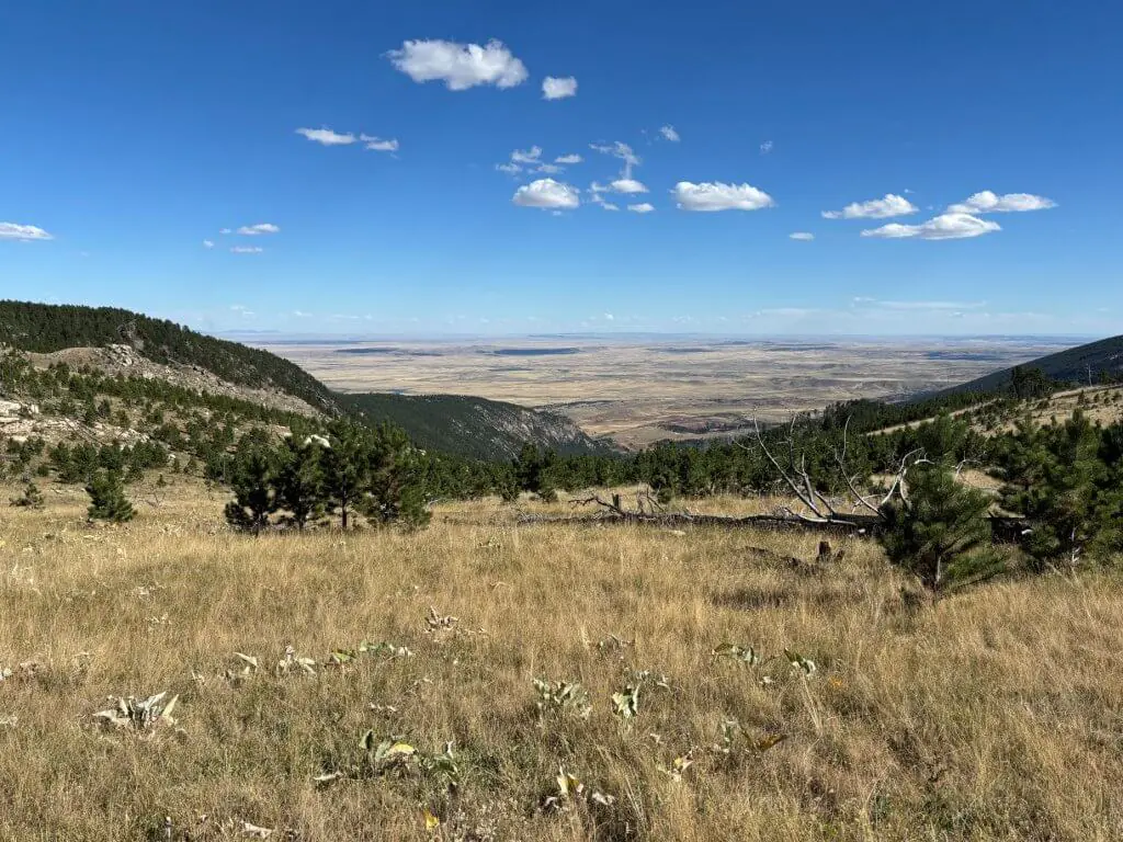 View from the top of Poison Creek Trail in Buffalo, WY, showcasing the Powder River Valley to the southeast and the Bighorn Mountain peaks to the northwest.