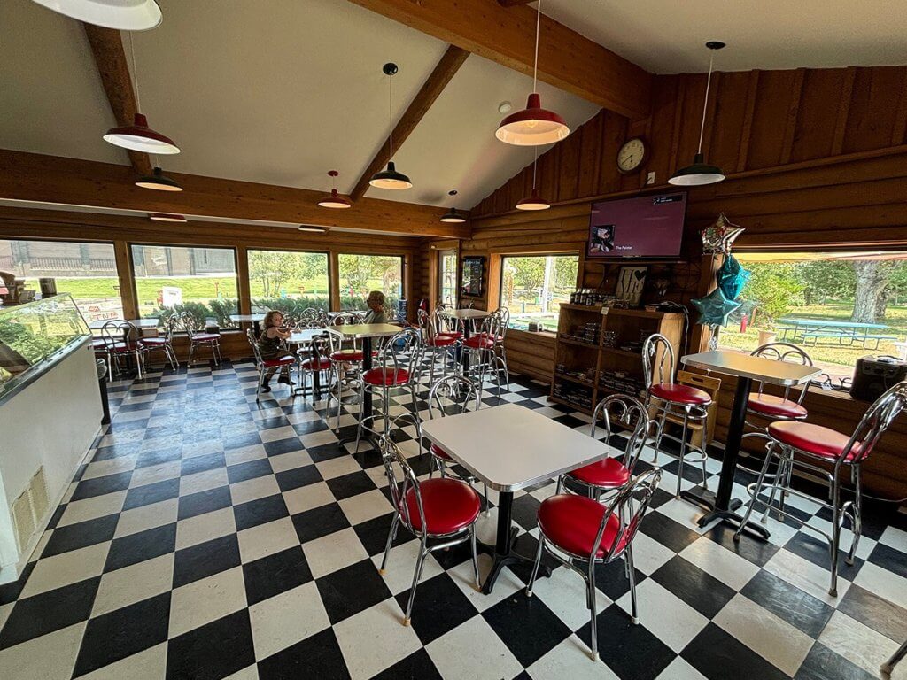 Interior of Creekside Family Fun Center in Buffalo, Wyoming, featuring a retro-style dining area with checkered floors and bright seating, ideal for casual gatherings and events.