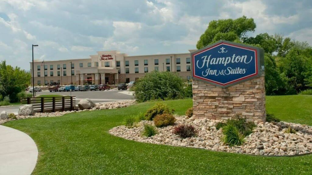 xterior view of Hampton Inn & Suites in Buffalo, Wyoming, featuring a welcoming facade and landscaped grounds, ideal for corporate and business retreats.