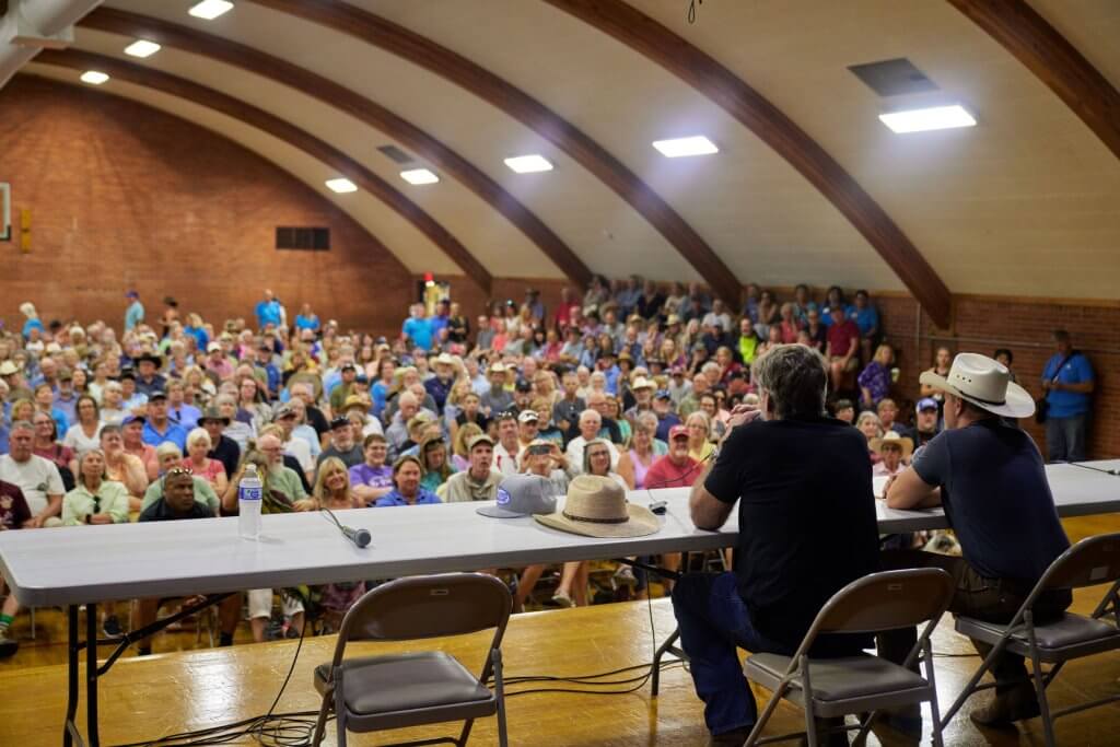 Audience attending a Longmire Days event at Bomber Mountain Civic Center in Buffalo, Wyoming, featuring a lively panel discussion in a spacious indoor venue.