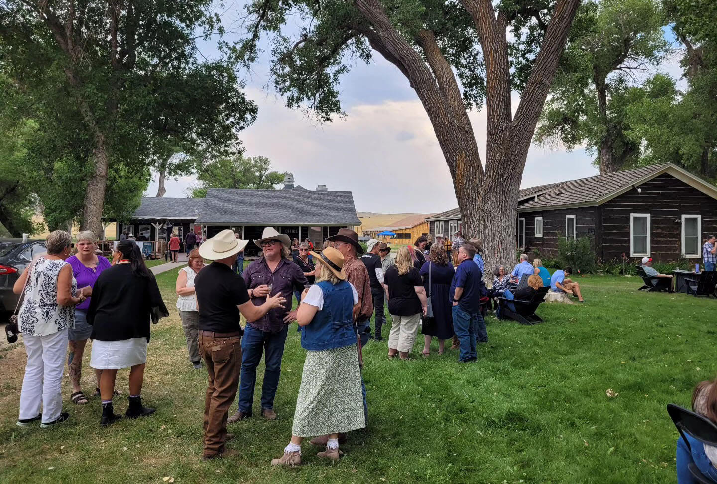 Guests enjoying an outdoor reception during Longmire Days at an event venue in Buffalo, Wyoming, with rustic buildings and a vibrant gathering atmosphere.