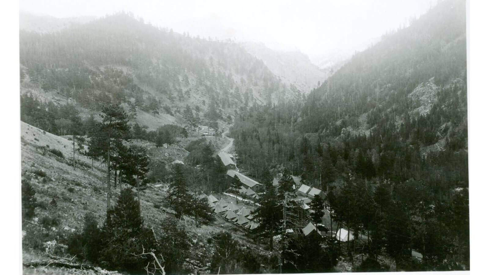 Origins of Crazy Woman Canyon Elevated view of the Civilian Conservation Corps camp nestled in Crazy Woman Canyon, showing tents and road work from the 1930s.