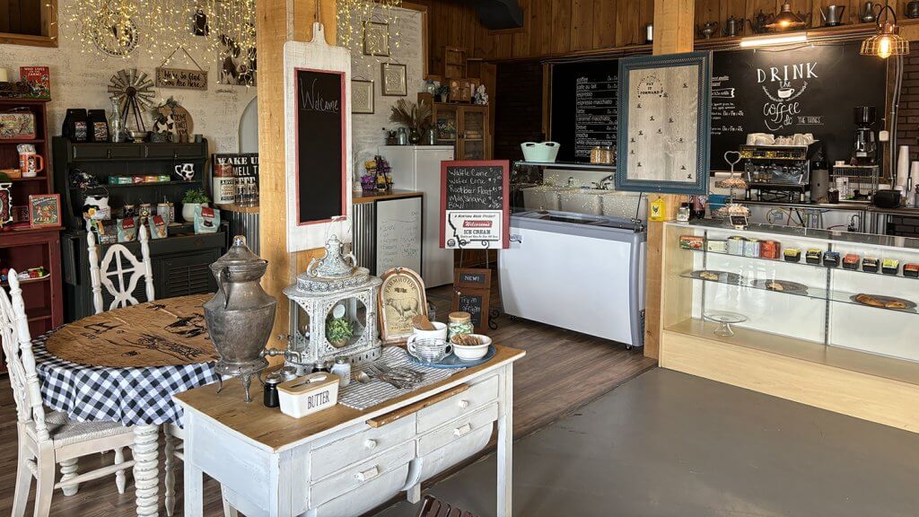 Hole in the Wall Cowlick Creamery interior showing rustic farmhouse-style ice cream shop with vintage décor, coffee bar, display case with ice cream flavors, and cozy seating area
