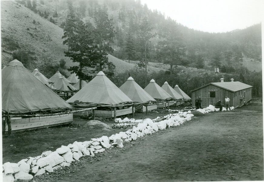 Origins of Crazy Woman Canyon Historic photo of Civilian Conservation Corps camp near Crazy Woman Canyon in the 1930s, showing rows of conical tents and a wooden mess hall.