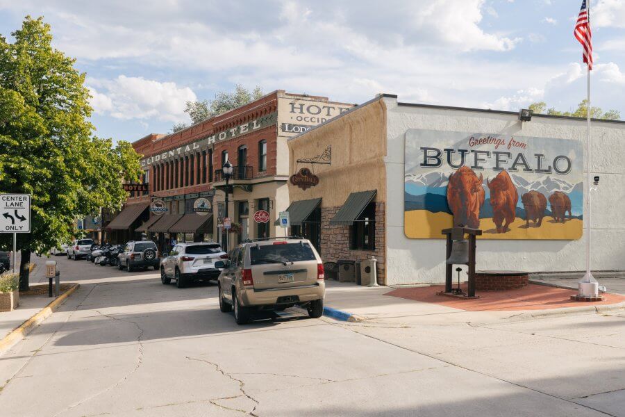 20 Free and Budget-Friendly Things to Do in Buffalo, Wyoming A scenic view of downtown Buffalo showing old brick buildings and the Clear Creek area surrounded by nature.
