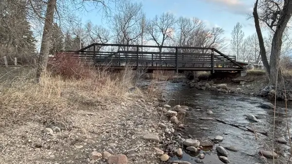 20 Free and Budget-Friendly Things to Do in Buffalo, Wyoming Historic iron footbridge over Clear Creek framed by leafless cottonwoods and rocky streambanks.