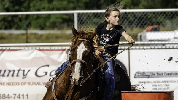 20 Free and Budget-Friendly Things to Do in Buffalo, Wyoming Young rider rounding a barrel on horseback at a summer evening cowgirls rodeo in Buffalo.