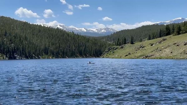 20 Free and Budget-Friendly Things to Do in Buffalo, Wyoming Kayaker paddling across the calm waters of Tie Hack Reservoir surrounded by alpine trees and mountain peaks.