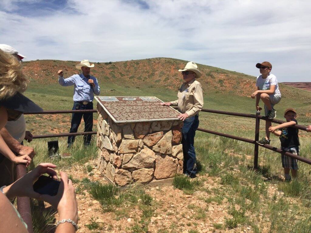 Hole in the Wall Tours visitors gathered around the Hole in the Wall Fight Memorial in Kaycee, WY