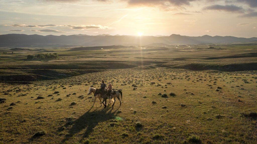 two people horseback riding in the country side of Johnson County, Wyoming
